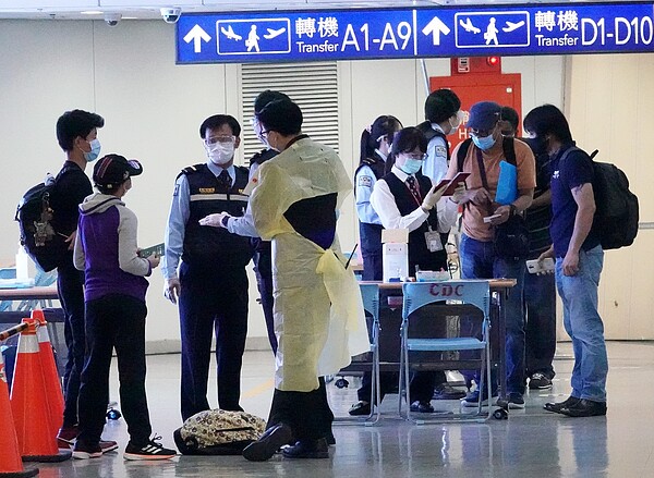 桃園機場第一航廈入境旅客，在通關前經由檢疫官與機場協勤人員進行新冠肺炎的檢疫工作。記者陳嘉寧／攝影 