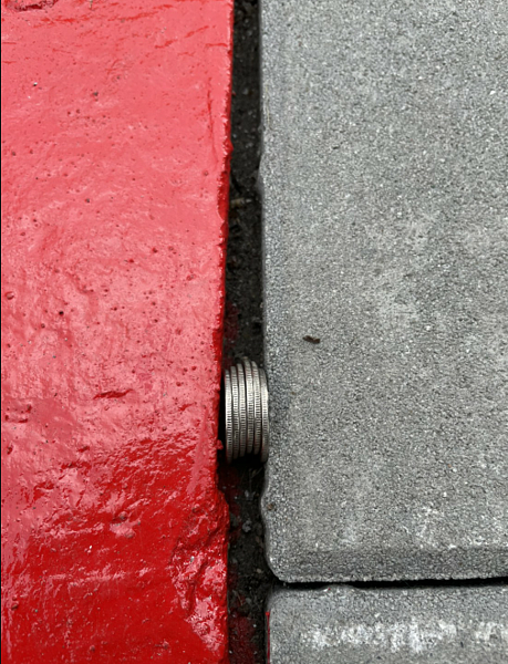 有里長指大湖社區入口人行道的工程品質差,工程才剛更新完工尚未驗收,光肉眼就可看到裂縫可放入數枚銅板。圖/台北市議員李明賢辦公室提供