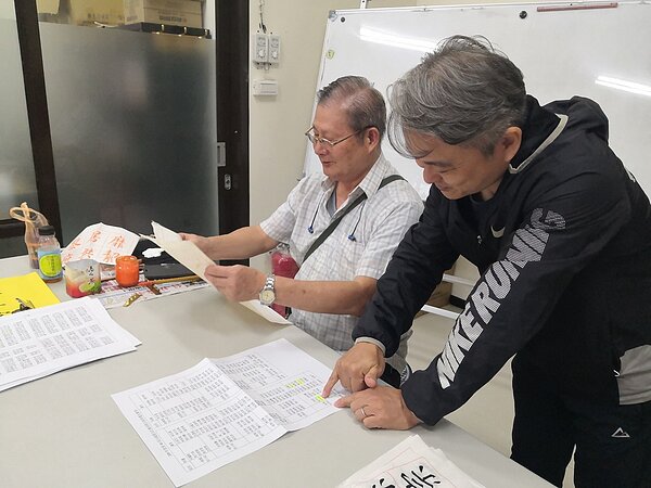 劉俊奇恭喜書法班的張友趁老師在書法比賽中獲得好成績。（圖／吳佳燕攝影）