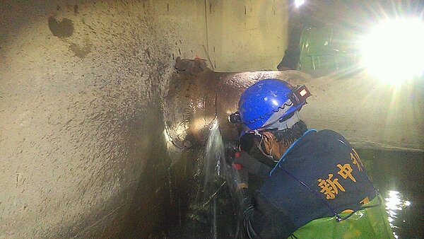 高雄市水利局委由專業人士清除穿越雨水箱涵的管線。圖/高雄市水利局提供