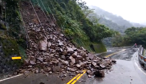 宜蘭連日多雨下不停，員山鄉前往福山植物園及雙連埤的道路邊坡落石大坍方，目前滾石仍持續滑落，尚未搶通。圖／邱姓讀者提供