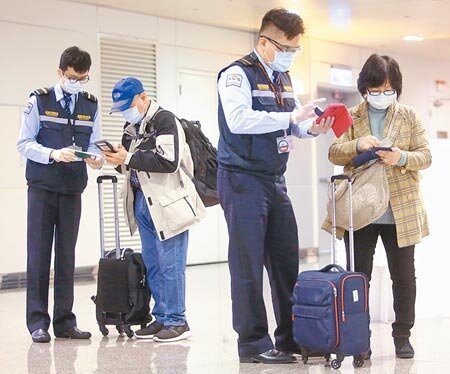桃園機場入境管制區內,檢疫人員正在協助旅客上網填寫健康聲明資料。(中時資料照片)