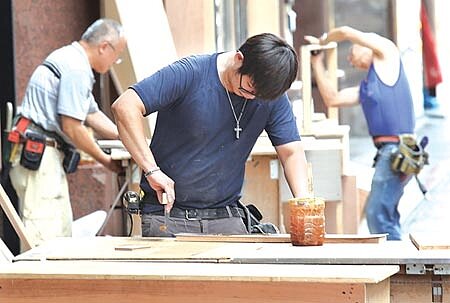 民眾裝修房屋前,應先作功課,過濾掉不良裝修業者。圖為商店裝潢工人在店外切割木材的情形。圖/本報資料照片