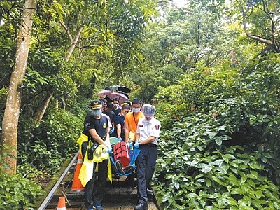 去年行政院「開放山林」政策,加上今年疫情衝擊,難以出國,國內登山健行人數暴增,卻也讓登山救難案件激增。圖為今年10月,60多歲男子在台北象山突然身體不適,由消防隊救下山急救。(民眾提供/胡欣男台北傳真)