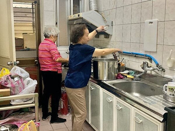 志工在廚房烹飪關懷據點的餐點。/攝自周希雯
