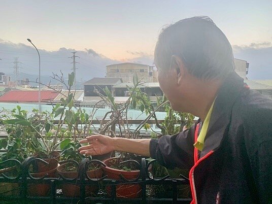 胡剛毅一一介紹花卉的種類。圖/周希雯攝