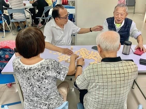長者歡樂地在玩桌遊。圖/周希雯攝
