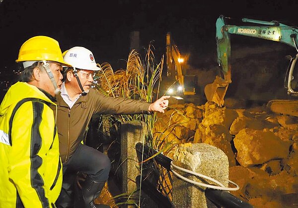 台鐵瑞芳－猴硐路段邊坡大面積坍塌，交通部長林佳龍13日晚間赴現場慰問維修人員，也宣布所有工程會在13日完成，14日正式通車。（台鐵提供）