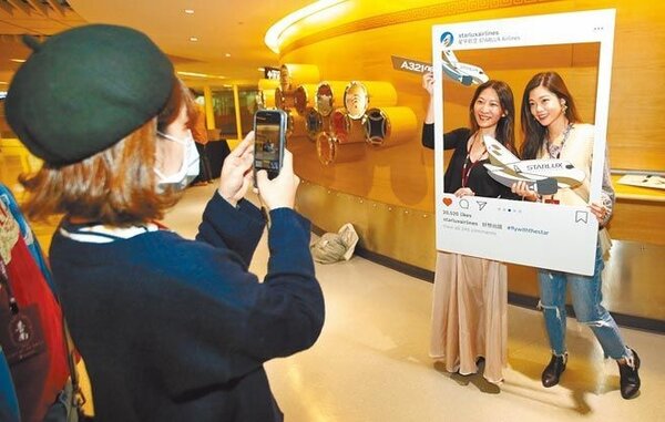 星宇航空「台北-台南雙城號」微旅行班機19日啟航，登機前旅客開心在候機室拍照打卡。圖／范揚光攝