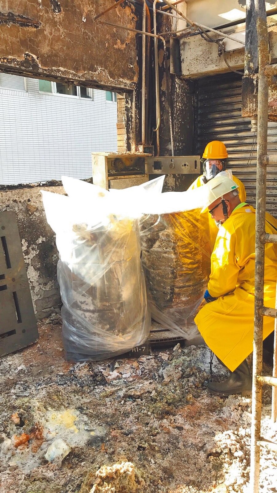 圖為旭富安全人員入廠發現仍有兩桶半金屬鈉,忙覆蓋防水塑膠布保安全。(桃園市消防局提供/姜霏桃園傳真)