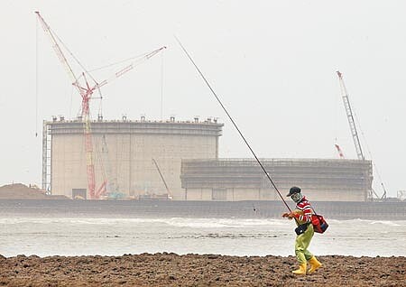 
行政院推出第三天然氣接收站外推方案，不過由於還要做「環境影響差異分析」 ，遭國民黨立委怒批還不知道能否通過，是「先騙公投」。圖為1名釣客前往白玉藻礁垂釣，遠方為興建中的天然氣儲存槽。（本報資料照片）
