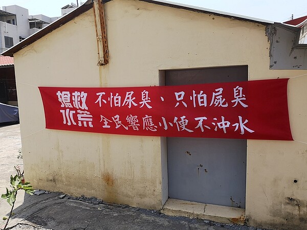 網友貼出呼籲節水的紅布條照片,標語及設計風格引起討論。圖/摘自臉書社團「路上觀察學院」