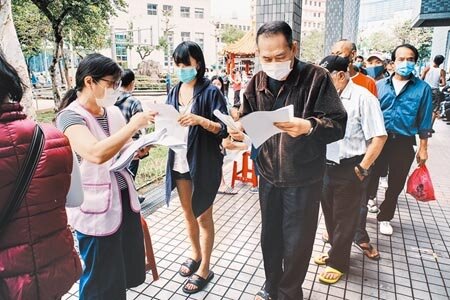 因疫情嚴峻,行政院會13日將紓困預算上限調高為6300億元。圖為2020年5月民眾排隊申請急難紓困補助。(本報資料照片)