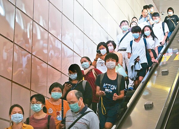 國內疫情急劇升溫,已經進入社區感染。圖為民眾搭乘捷運配戴口罩。報系資料照