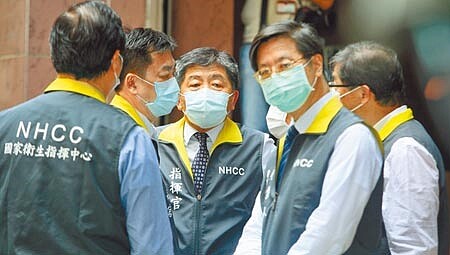 行政院長蘇貞昌等人15日赴中央流行疫情指揮中心視察,指揮中心指揮官陳時中(中)在門口等待,並與同仁交換意見。(張鎧乙攝)