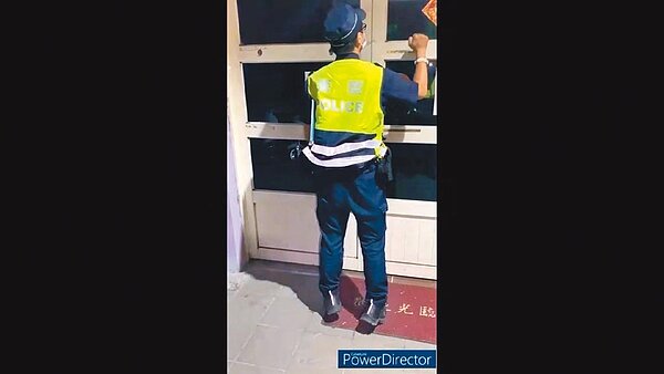 宜蘭警方14日深夜查察一家違反防疫禁令繼續營業的視聽歌唱業者，但業者拒不開門。（警方提供／胡健森宜蘭傳真）