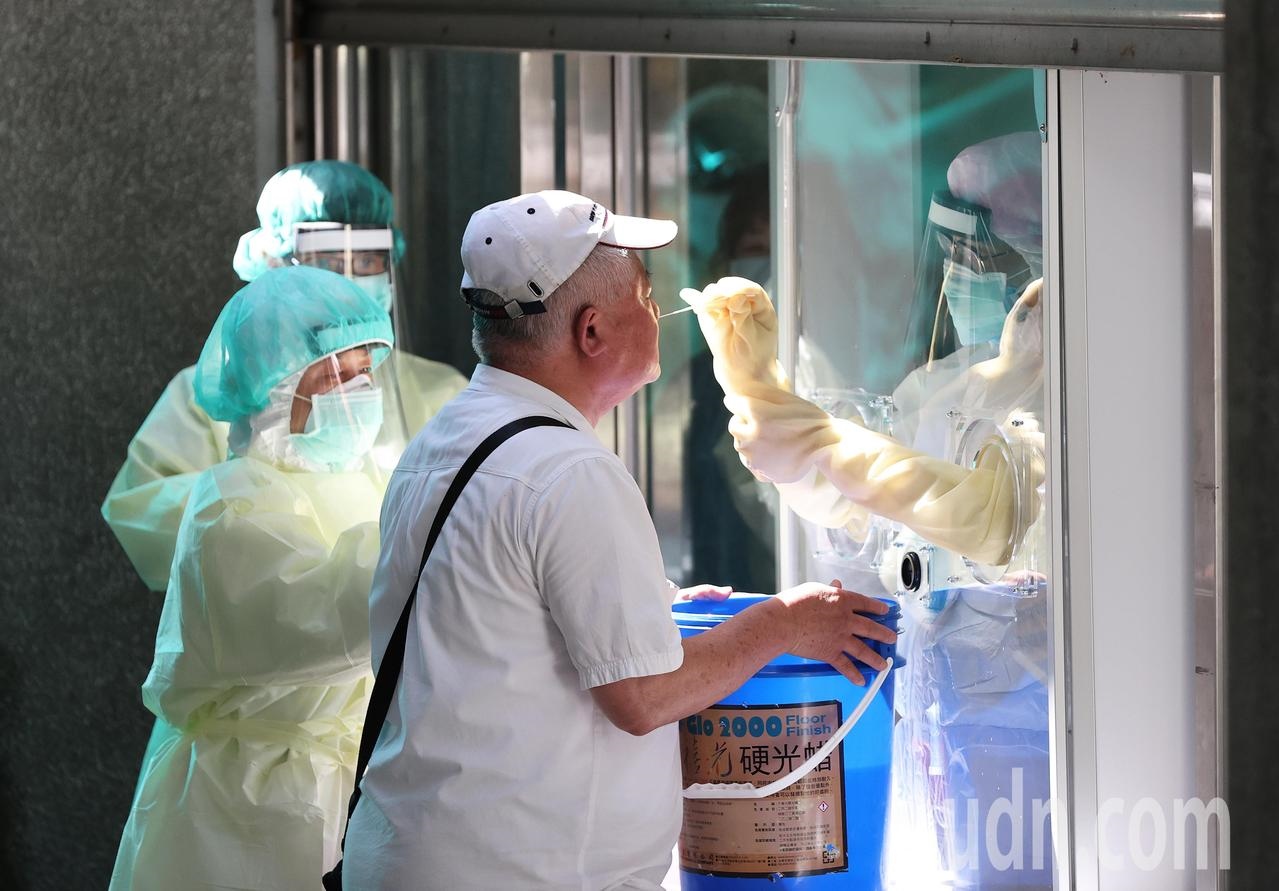 新冠肺炎嚴峻，圖為醫護人員隔著玻璃為民眾採檢。記者潘俊宏／攝影