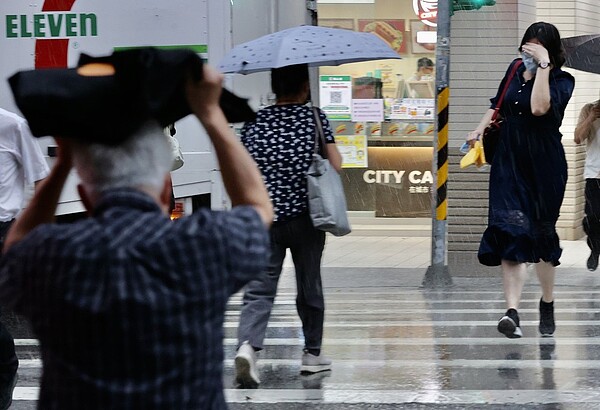 台北市昨日傍晚時分下了一場陣雨，不少未帶傘的市民淋雨前行。記者許正宏／攝影