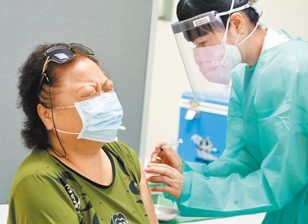 板橋亞東醫院開放院內醫護及工作人員施打疫苗，1位民眾打針前緊張地緊閉雙眼。（范揚光攝）
