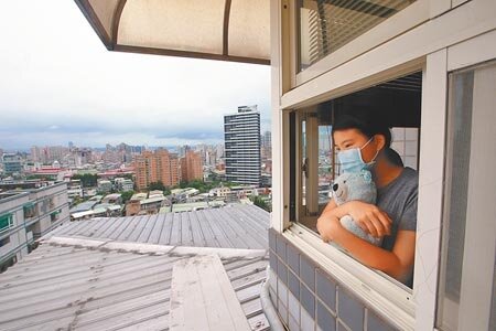 根據Yahoo!平台公布的線上民調結果，未來若開放自費打疫苗，有8成以上的民眾願意施打。圖為全國三級警戒，民眾在家中窗邊透透氣。（陳信翰攝）