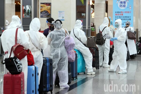 昨天上午松山機場國際線爆滿，搭機旅客穿隔離衣戴防護鏡防疫。記者曾吉松／攝影 