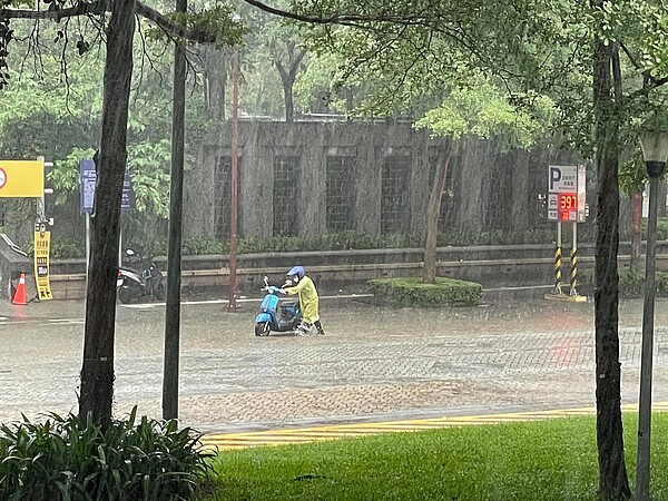 北市基隆路地下道旁因午後豪雨發生積水情形,民眾機車拋錨下車牽引。圖/好房網News記者呂詠柔攝影