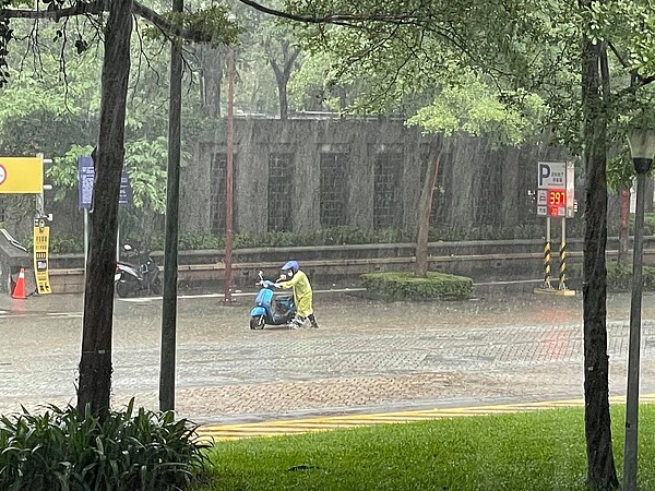 北市基隆路地下道旁因午後豪雨發生積水情形，民眾機車拋錨下車牽引。圖／好房網News記者呂詠柔攝影