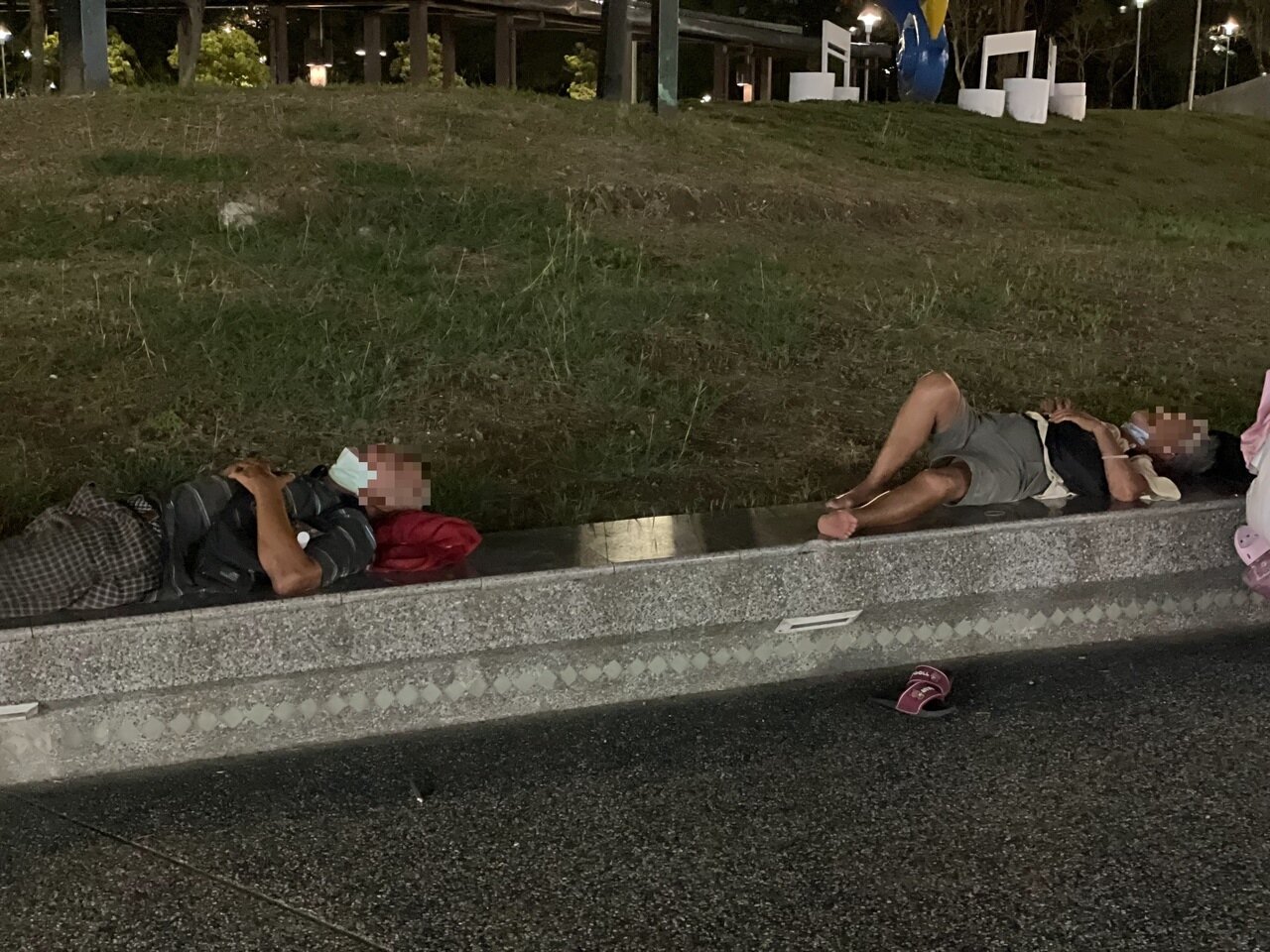 嘉市文化公園靠近民族路、文化路口處,街友晚間躺下睡覺,有戴口罩但都拉下至下巴。記者林伯驊/攝影