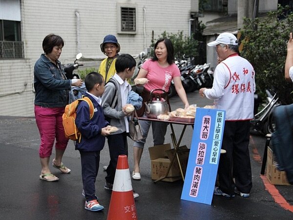 義工響應低碳上學日向學生發放早餐 。圖／蔡綉花提供