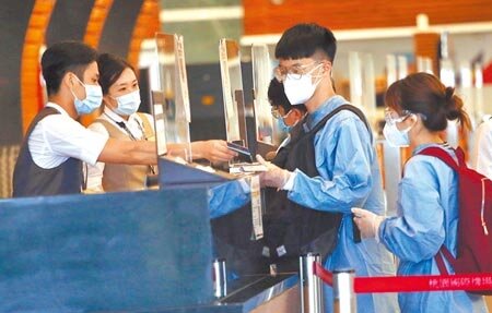 陳時中表示,疫苗護照只是文件、不是證件,施打國產疫苗一樣可以出國,「差別只在於檢疫過程」。圖為桃園機場第一航廈出境大廳內,身穿防護衣的旅客正在辦理報到手續。(范揚光攝)