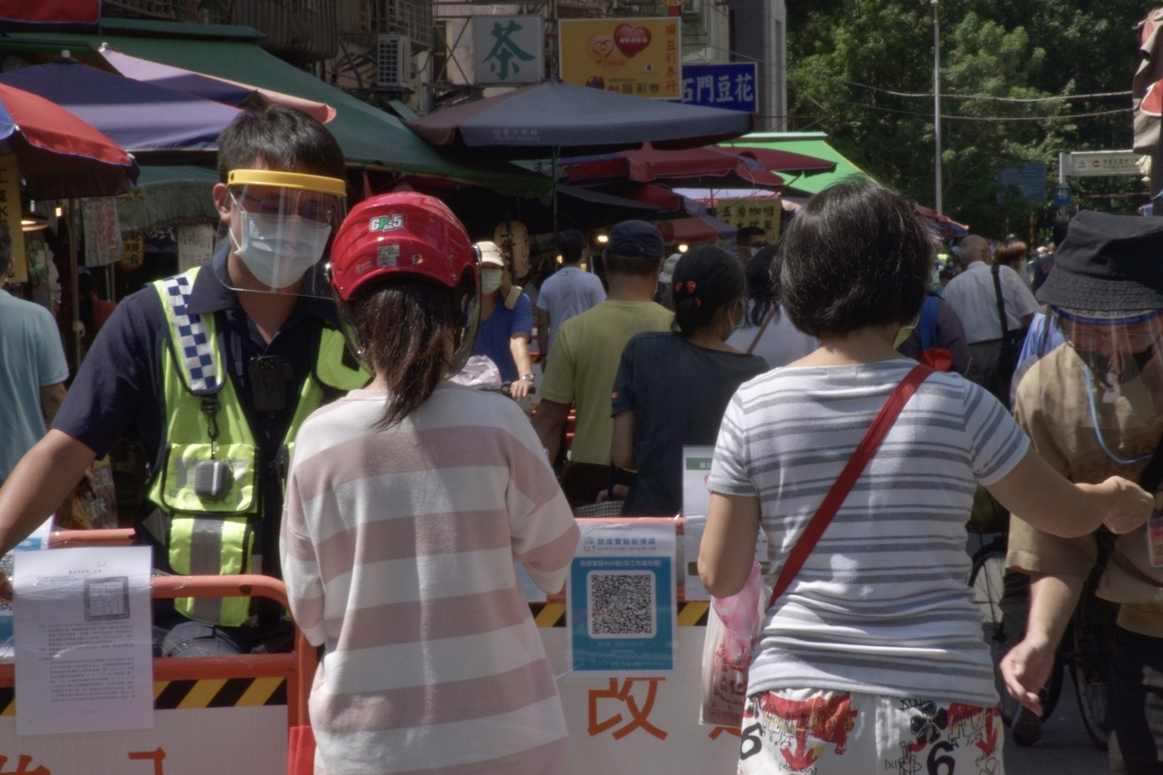 	濱江市場出入口都有警察和市場處的公務員站崗，檢查民眾的身份證號尾數。記者鍾維軒／攝影