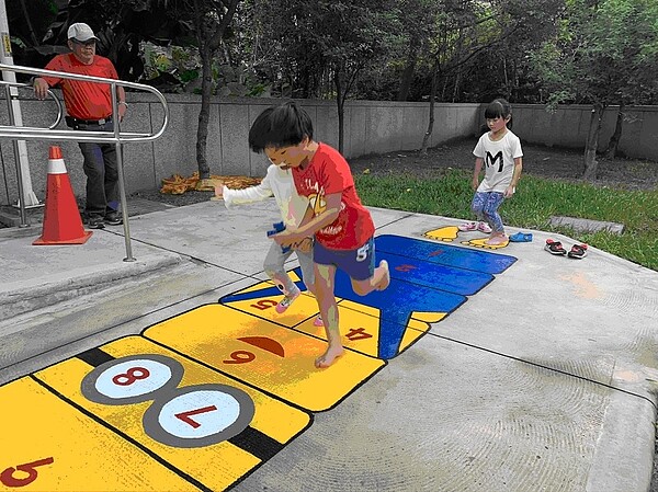 於地板繪製的跳房子遊戲,也是小小兵主題系列,總是能讓小朋友玩得不亦樂乎。圖/詹汝提供