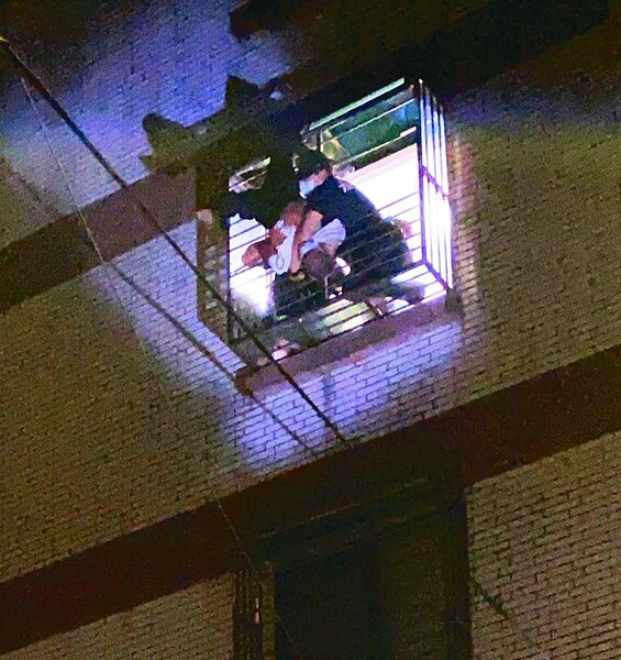 王姓男子酒醉從五樓頂墜落,頭下腳上卡在四樓鐵窗外,倒栽蔥約四十分鐘被救回,過程驚險。記者邱瑞杰/翻攝