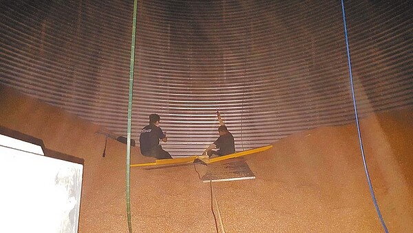 嘉義縣義竹鄉農會柯姓員工不慎掉入玉米堆,只剩臉部露在外面,消防人員將其固定避免繼續下沉後救出。(讀者提供/張亦惠嘉縣傳真)