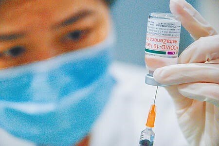 新冠肺炎疫情嚴峻,全台高齡長者15日開始施打疫苗,各地亂象不一。圖為16日護理人員小心翼翼的準備疫苗。(羅永銘攝)
