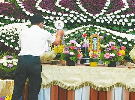 殯葬服務人員處理遺體面臨染疫高度風險,為維護其職業安全,在內政部積極爭取下,中央流行疫情指揮中心22日已同意將實際處理遺體的殯葬服務人員,納入第2類防疫人員,優先接種疫苗,圖為禮儀公司員工佈置追思會場。(陳怡誠攝)