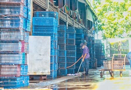 新北市家禽運銷合作社爆發群聚感染事件,引發關注;27日工作人員以水柱清理場地。(陳信翰攝)