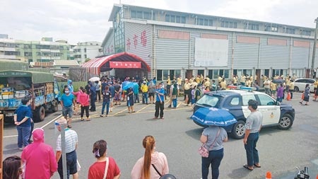 台南市安南區發生家族群聚感染，怡安路果菜市場篩檢站出現大批民眾等著篩檢。（程炳璋攝）