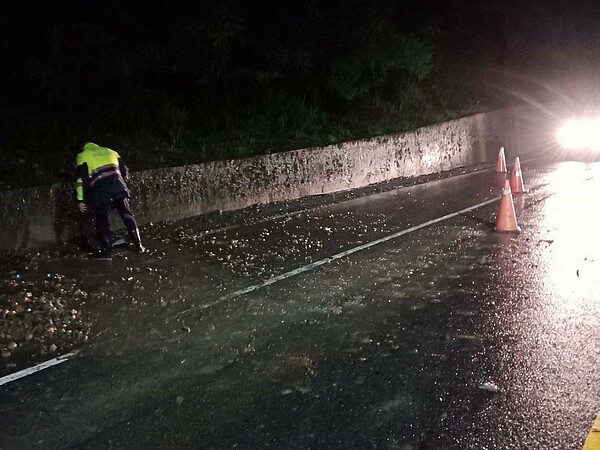 高雄田寮區台28線18.5K處，凌晨1時許，邊坡有土石滑落路面，碎石影響通行，警方獲報後冒雨排除。圖／讀者提供