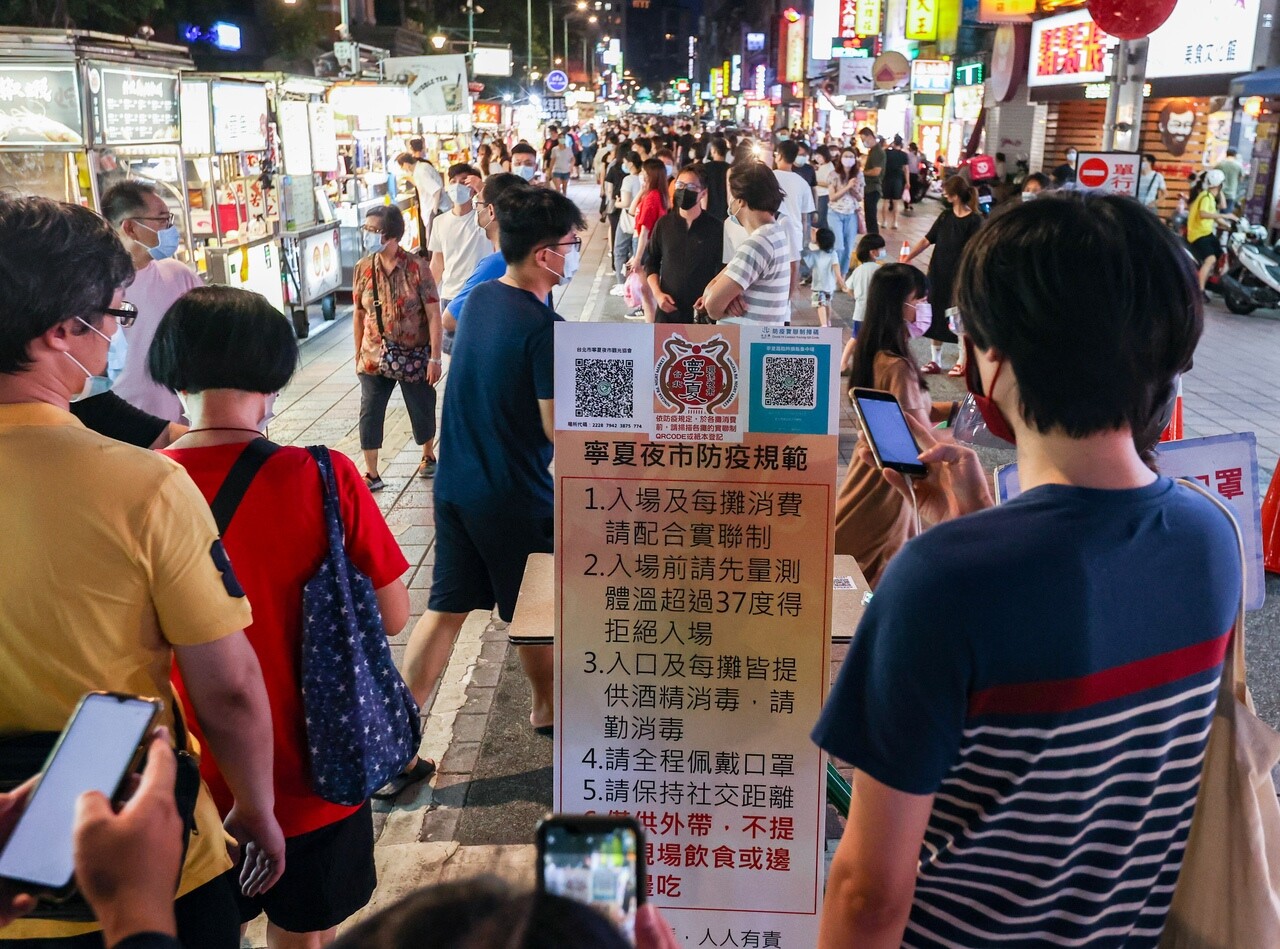 台北市寧夏夜市「微解封」後人潮湧現，消費者謹守防疫規定，落實實聯制，無人邊走邊吃。記者曾原信／攝影