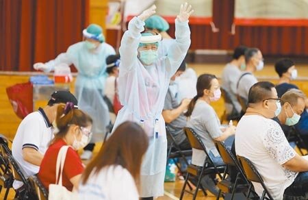 為期7天的台北市市場攤商疫苗接種專案6日持續進行，現場護理師大動作招呼剛抵達的民眾入座。（季志翔攝）