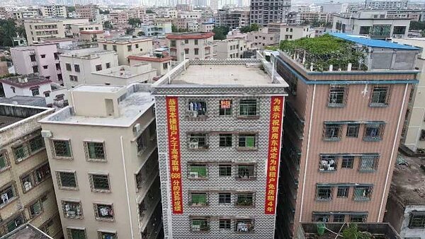 一名房東因為房客的兒子高考取得了608分的好成績,竟掛紅布條慶祝還免去房客未來4年房租。圖/取自《搜狐新聞》