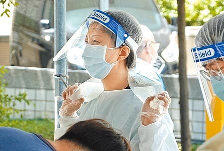 
中央流行疫情指揮中心自7月2日起針對所有境外移入個案做基因定序，僅一周就驗出3例Delta印度變異株、1例Alpha英國變異株，以及1例Gamma巴西變異株。圖為新北戶外採檢站拿冰敷袋抵禦酷暑的護理人員。（姚志平攝）
