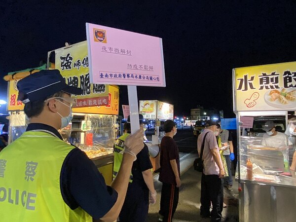 台南夜市「開工第一天」,員警拿大聲公宣傳防疫。記者周宗禎/翻攝