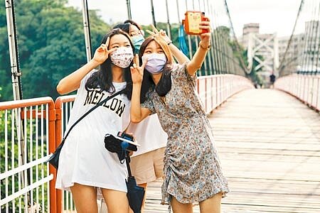 7月13日正式微解封,封閉許久的國家公園、風景區、觀光旅遊區重新開放,碧潭風景區有民眾開心的在吊橋上拍照留念。(郭吉銓攝)