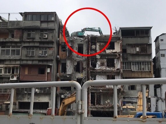 民眾看到有怪手停在正拆除的公寓頂樓上，不禁好奇它到底是怎麼開上去的。圖／翻攝自《爆廢1公社》