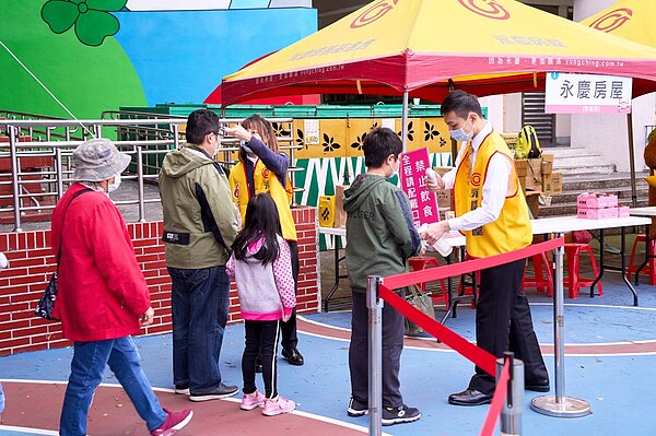 永慶房屋同仁協助里長進行防疫措施，量體溫、噴酒精，讓活動既安心又順利。圖／永慶房產集團提供