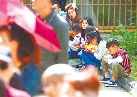小朋友長時間滑手機,恐傷眼力。(本報資料照片)