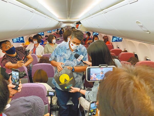 帛琉總統惠恕仁（中）在飛機上贈送所有旅客具帛琉特色的防水袋。圖／KKday提供