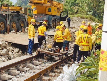 花蓮因車廂出軌，約有100多公尺鐵軌受損嚴重，台鐵派員研讀檢視軌道安全並敲打鐵軌構造，抽離破損的結構。圖／王志偉攝